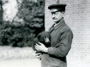 Un gardien tient un ourson paresseux au zoo de Londres, août 1921